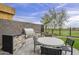A well-equipped outdoor kitchen and dining area with a built-in grill and views of the golf course at 37200 N Cave Creek Rd # 1023, Scottsdale, AZ 85262
