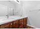 Bathroom with double sink vanity, white countertop, and wood cabinets at 44032 W Garden Ln, Maricopa, AZ 85139