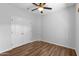 A bright bedroom featuring wood-look floors, a ceiling fan, and double door closet at 44032 W Garden Ln, Maricopa, AZ 85139