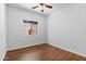 Bright bedroom featuring a ceiling fan, window, and wood-look flooring at 44032 W Garden Ln, Maricopa, AZ 85139