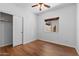 This bedroom features a closet with sliding doors, ceiling fan, and wood-look flooring at 44032 W Garden Ln, Maricopa, AZ 85139