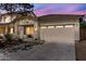 Charming single-story home featuring a neutral stucco exterior, a two-car garage, and desert landscaping at 44032 W Garden Ln, Maricopa, AZ 85139