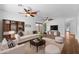 Bright living room with hardwood floors, stylish furniture, and two ceiling fans at 44032 W Garden Ln, Maricopa, AZ 85139