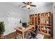 This home office features a ceiling fan, built-in bookshelf, and desk at 44032 W Garden Ln, Maricopa, AZ 85139