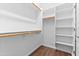 Spacious walk-in closet featuring built-in shelving and hanging rods for optimal organization at 44032 W Garden Ln, Maricopa, AZ 85139