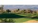 Scenic golf course featuring rolling green hills, trees, and mountain views for a picturesque outdoor experience at 6162 E Redmont Dr, Mesa, AZ 85215