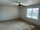 Spacious bedroom featuring neutral carpet, ceiling fan, and a window with natural light at 10756 W Taft St, Phoenix, AZ 85037