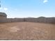 A dirt backyard bordered with a brick fence and clear skies overhead at 15995 W Cottontail Ln, Surprise, AZ 85387
