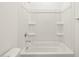 An all white bathroom with a shower-tub combo with built in shelving at 15995 W Cottontail Ln, Surprise, AZ 85387