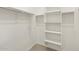 Walk-in closet with shelving and ample hanging storage, featuring carpeted floors at 15995 W Cottontail Ln, Surprise, AZ 85387