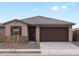 Charming single-story home with a stone-accented facade, a two-car garage, and a well-manicured front yard at 15995 W Cottontail Ln, Surprise, AZ 85387