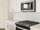 Close up of stainless steel microwave and gas range with white backsplash and stone countertops at 15995 W Cottontail Ln, Surprise, AZ 85387