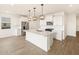 Modern kitchen with large white countertop island with a stainless steel faucet and sink at 15995 W Cottontail Ln, Surprise, AZ 85387