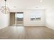 Bright living room with wood-style floors and modern light fixture at 15995 W Cottontail Ln, Surprise, AZ 85387