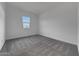An empty bedroom with neutral carpet, white walls, and a view out the window at 28250 N 134Th Ave, Peoria, AZ 85383
