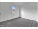 An empty bedroom with neutral carpet, white walls, and a view out the window at 28250 N 134Th Ave, Peoria, AZ 85383