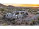 Stunning aerial view of estate home at sunset with mountain views and desert landscaping at 10739 E Diamond Rim Dr, Scottsdale, AZ 85255