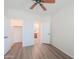 Bedroom with wood floors and ceiling fan offering a closet and a bathroom at 43594 W Bravo Ct, Maricopa, AZ 85138