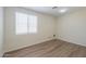Clean bedroom with window and plank floors at 43594 W Bravo Ct, Maricopa, AZ 85138