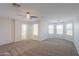 This spacious bedroom offers plenty of natural light with plush carpeting and a ceiling fan at 43594 W Bravo Ct, Maricopa, AZ 85138