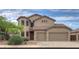 Tan two-story home with a three car garage, tile roof, desert landscaping, and secure window coverings at 43594 W Bravo Ct, Maricopa, AZ 85138