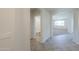 Hallway boasts tile flooring and leads to a bathroom and an arched opening to the living room at 43594 W Bravo Ct, Maricopa, AZ 85138