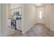 Kitchen space includes stainless steel appliances and white cabinets with view of front entry at 43594 W Bravo Ct, Maricopa, AZ 85138