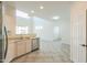 Modern kitchen with stainless steel appliances, neutral cabinets, and an open layout to other living spaces at 43594 W Bravo Ct, Maricopa, AZ 85138