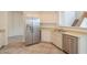 Well-appointed kitchen with stainless steel fridge and ample counter space adjacent to the staircase at 43594 W Bravo Ct, Maricopa, AZ 85138