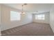 Bright living room with carpet, chandelier and ceiling fan is a great place to entertain at 43594 W Bravo Ct, Maricopa, AZ 85138