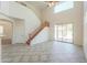 Open-concept living room with tile floors, staircase, and sliding glass doors leading to the backyard at 43594 W Bravo Ct, Maricopa, AZ 85138