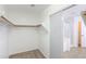 A walk-in closet has wooden racks and a sliding door that reveals a view of the bathroom at 43594 W Bravo Ct, Maricopa, AZ 85138