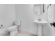 A compact bathroom with a pedestal sink, toilet, and modern fixtures at 5845 S Romano --, Mesa, AZ 85212