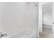 A clean white bathroom showcasing a tub and shower combo, plus wood-look tile flooring at 5845 S Romano --, Mesa, AZ 85212