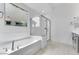 Bright bathroom with a soaking tub, glass enclosed shower, and a white vanity with gray cabinets at 5845 S Romano --, Mesa, AZ 85212