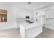 Bright kitchen with quartz countertops, white cabinets, and a large island at 5851 S Romano --, Mesa, AZ 85212