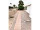 Low-maintenance backyard featuring gravel ground cover and a quaint brick pathway at 8257 E Dutchman Dr, Mesa, AZ 85208