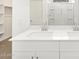 Bathroom with bright white vanity top, double sinks and a large mirror at 16034 W Desert Hollow Dr, Surprise, AZ 85387