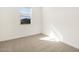 This bedroom has neutral carpet and a sunlit window at 16034 W Desert Hollow Dr, Surprise, AZ 85387