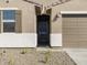 Home's entryway features a dark door with sidelight, set within a charming facade at 16034 W Desert Hollow Dr, Surprise, AZ 85387