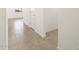 Bright hallway featuring neutral tile flooring, white walls, and sleek white doors at 16034 W Desert Hollow Dr, Surprise, AZ 85387