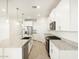 Contemporary kitchen boasts white cabinetry, granite countertops, and stainless steel appliances at 16034 W Desert Hollow Dr, Surprise, AZ 85387