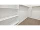 Walk-in closet with built-in shelving and plush carpet at 16034 W Desert Hollow Dr, Surprise, AZ 85387
