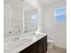 Bathroom featuring a double sink vanity, large mirror, and shower at 16062 W Prickly Pear Trl, Surprise, AZ 85387