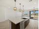 Modern kitchen features a center island with a sink, stainless steel appliances, and pendant lighting at 16062 W Prickly Pear Trl, Surprise, AZ 85387