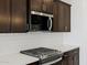 Detail shot of a modern gas range and microwave, set against a stylish white backsplash at 16062 W Prickly Pear Trl, Surprise, AZ 85387