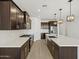 Spacious kitchen with stainless steel appliances, dark cabinets, and a center island at 16062 W Prickly Pear Trl, Surprise, AZ 85387