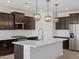 Modern kitchen with stainless steel appliances, a center island, and dark cabinetry at 16062 W Prickly Pear Trl, Surprise, AZ 85387