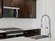 Close-up of modern kitchen appliances, including a gas cooktop, microwave, and stylish backsplash at 16062 W Prickly Pear Trl, Surprise, AZ 85387