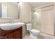 Well-lit bathroom with a tiled shower, wood vanity, and decorative mirror at 4937 N Granite Reef Rd, Scottsdale, AZ 85251